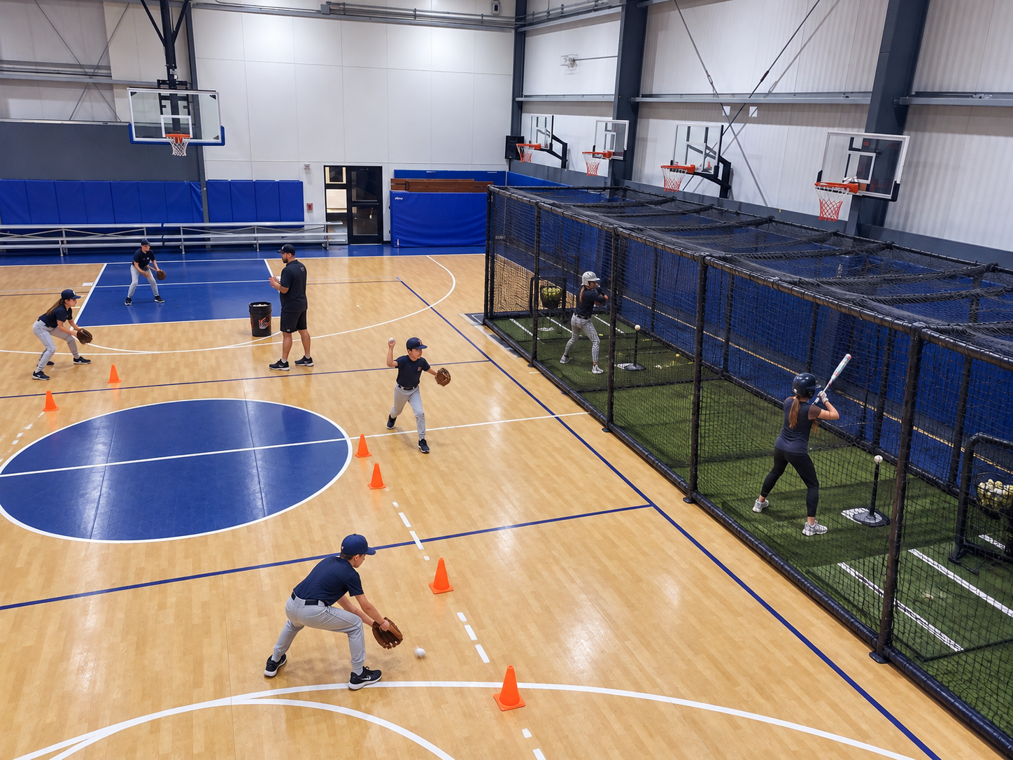 Kids training baseball indoors with a batting cage and fielding lane