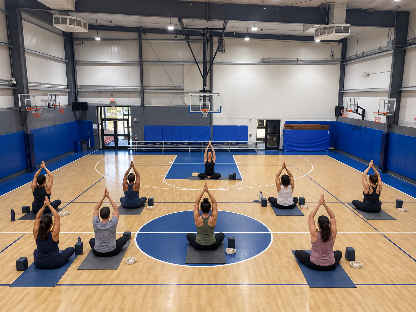 Adults in a yoga class on the House of Sports gym court
